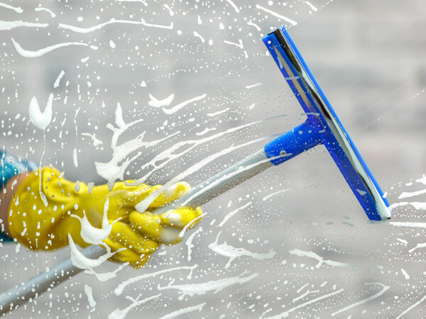 A squeegee being used to clean a window